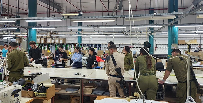 Uniformed participants of a training session at work tables in the production hall
