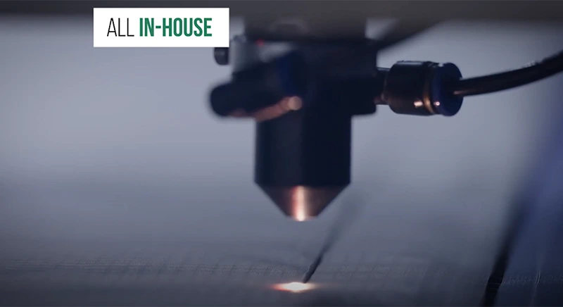 Laser cutting head cutting fabric, with the caption "All in-house"