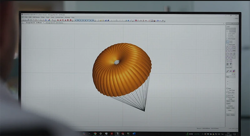 Screen showing a 3D model of a round parachute canopy with its lines in design software