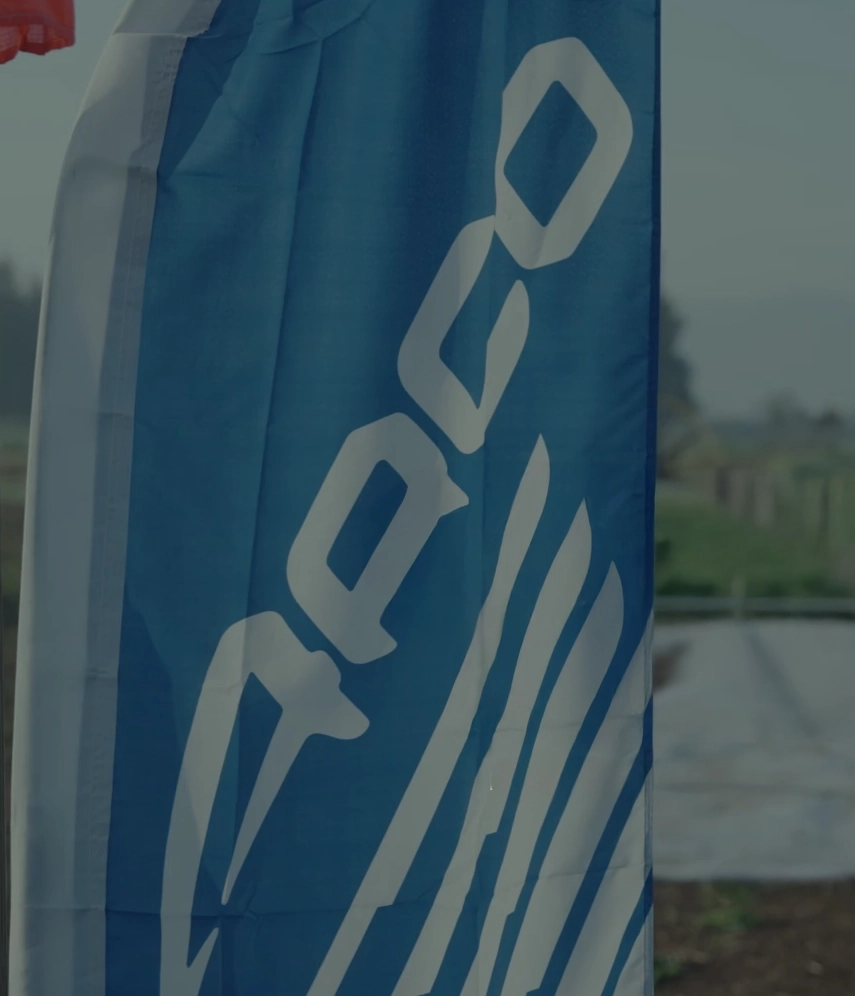 Blue beach flag with the APCO logo outdoors