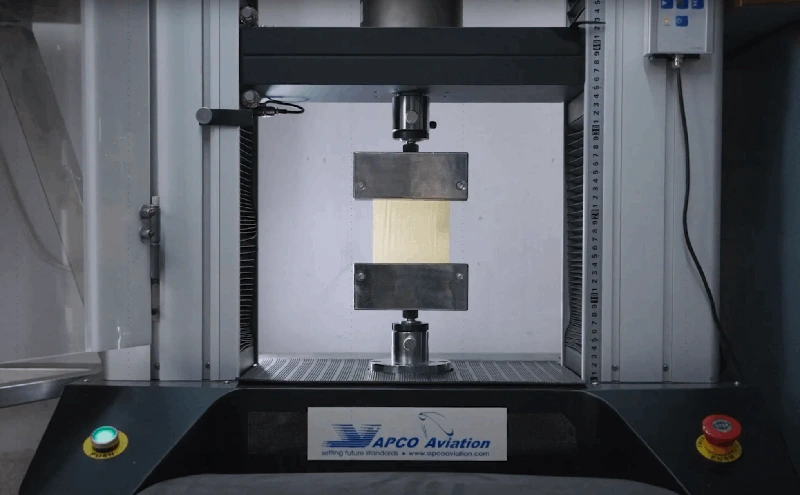 Testing machine with a material sample clamped between two compression plates