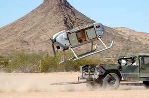 Paratrike aircraft during a rolling take-off from a moving off-road vehicle in the desert