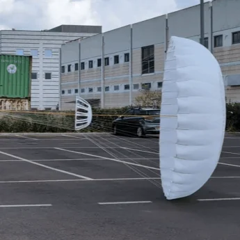 Rectangular deceleration canopy inflating on the ground in a car park