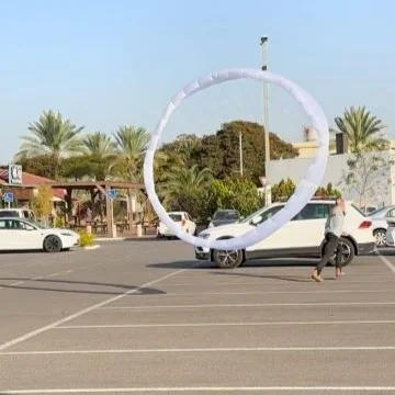 Annular canopy deploying above a car park with a person next to it