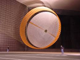 Large orange and white band parachute during a test in a wind tunnel hall